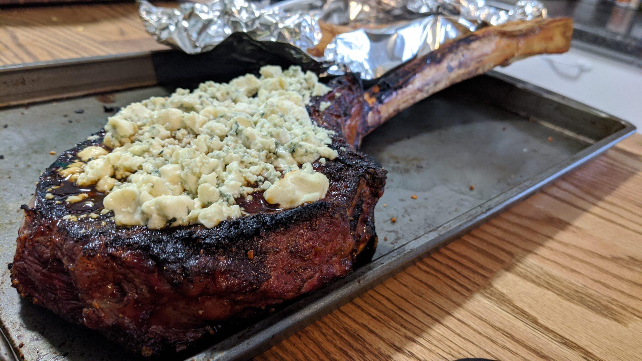 Tomahawk steak with blue cheese crumble done on the grill.